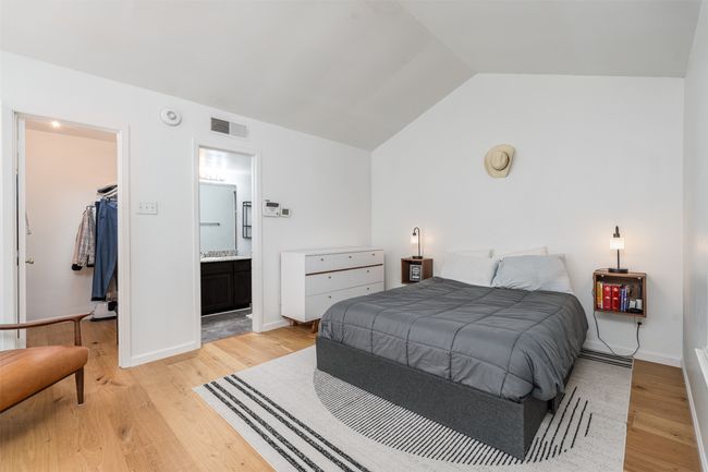 Bedroom with a spacious closet, light wood finished floors, lofted ceiling, ensuite bathroom, and a closet | Image 4