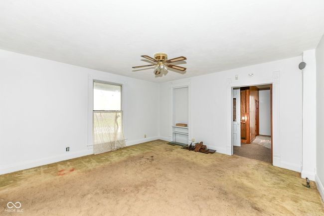Living Room with built in bookshelf, hardwood floors underneath the carpet | Image 6