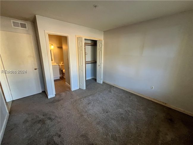 Unfurnished bedroom featuring a closet and dark carpet | Image 11