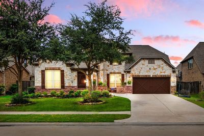 Welcome home to 27810 Desert Manor located on a quiet cul-de-sac street in Cinco Ranch Northwest and zoned to Katy ISD! This stunning home has lovely curb appeal, a well-manicured lawn, beautiful landscaping, stone/brick elevation, dark stained front door with glass detailing, covered front porch, courtyard, traditional style, dark stained shutters, beautiful outdoor lanterns and a three car driveway! | Image 1