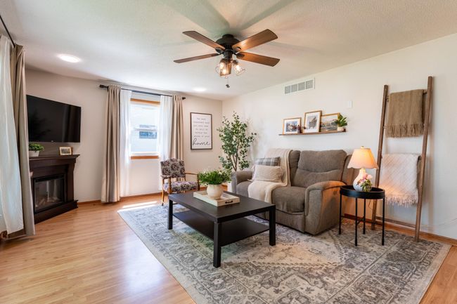 Cozy living room with fresh paint, new double curtain rods & ceiling fan. | Image 4