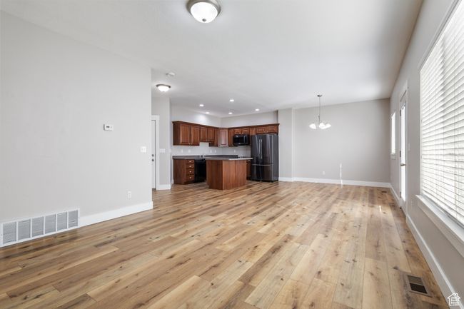 Unfurnished living room with a chandelier, light wood-type flooring, and recessed lighting | Image 8