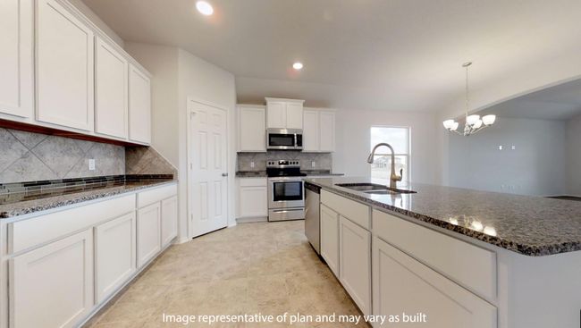 Kitchen featuring appliances with stainless steel finishes, a sink, white cabinets, backsplash, and a chandelier | Image 6