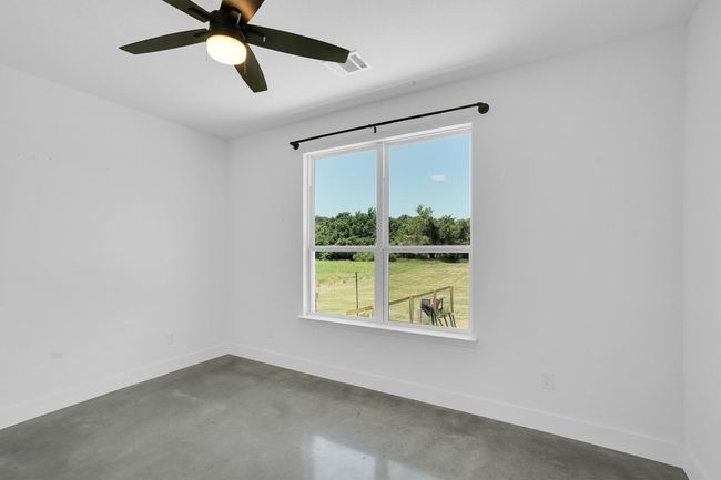 Empty room featuring concrete floors, baseboards, and ceiling fan | Image 25
