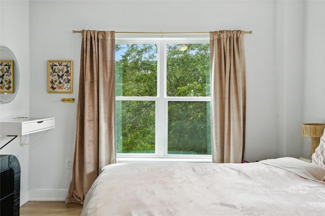 Bedroom with multiple windows and wood finished floors | Image 15