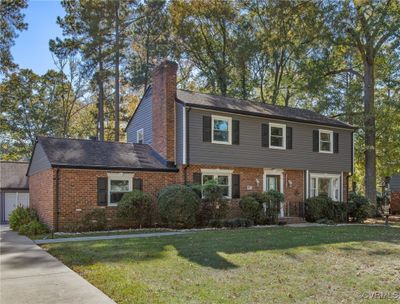 View of front of property featuring a front lawn and a garage | Image 1