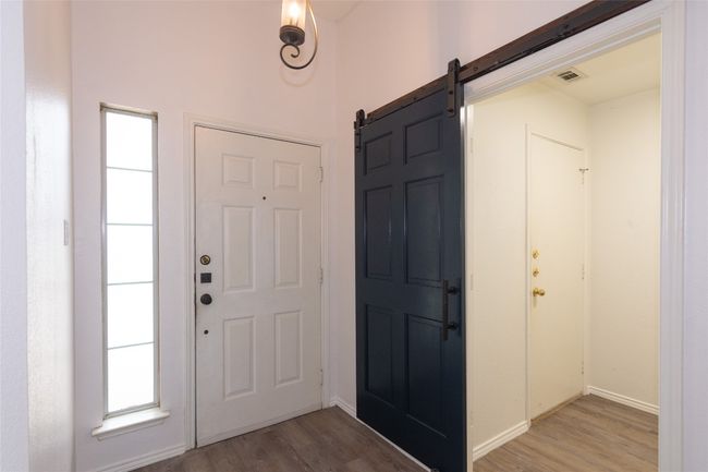 Entryway featuring a barn door and light wood-style flooring | Image 4