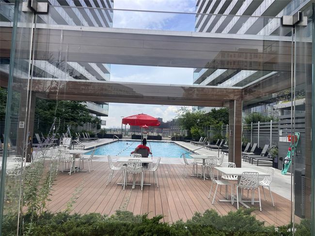 Community pool featuring a wooden deck and outdoor dining area | Image 10