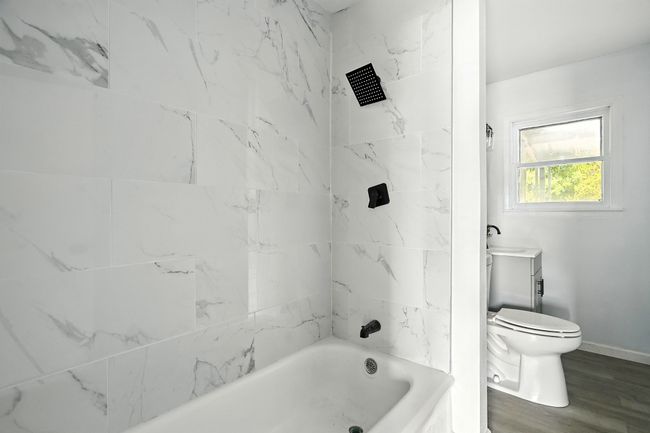 Bathroom with bathing tub / shower combination, vanity, and wood finished floors | Image 22