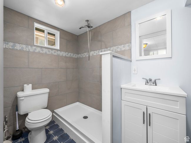 Full bath with a tile shower, tile walls, and vanity | Image 17