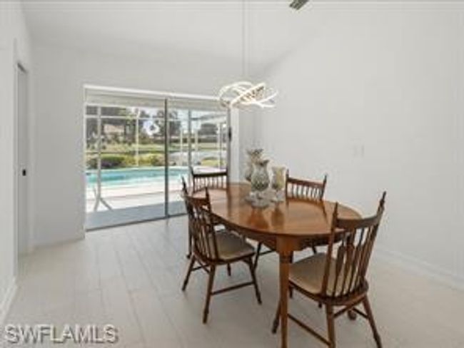 Dining area with light wood-type flooring and a chandelier | Image 10