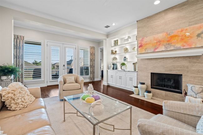 Lighted floating shelves create a striking focal point, while the beautifully tiled fireplace adds a cozy yet sophisticated ambiance. | Image 13