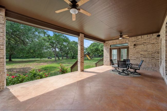 View of patio / terrace with fence, outdoor dining space, a ceiling fan, and a playground | Image 32