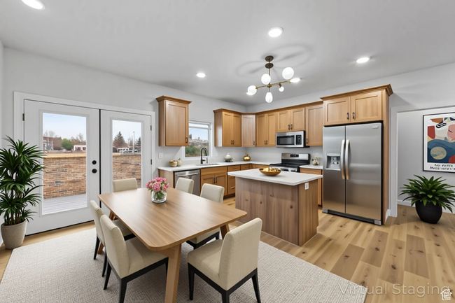 Kitchen featuring light wood-type flooring, light countertops, a kitchen island, appliances with stainless steel finishes, and a sink | Image 12