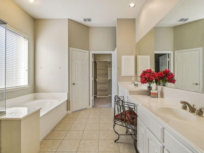 Full bathroom featuring double vanity, healthy amount of natural light, a garden tub, tile patterned floors, and recessed lighting | Image 9