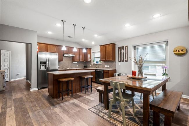 Dining area featuring wood laminate floors, baseboards, and recessed lighting | Image 9