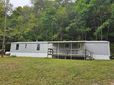 Manufactured / mobile home featuring a front lawn and a deck | Image 1