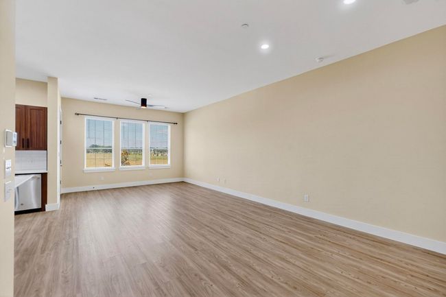 Unfurnished living room featuring light wood-style floors, a ceiling fan, and recessed lighting | Image 7