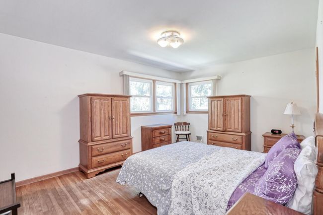 Bedroom with baseboards, visible vents, and light wood finished floors | Image 16