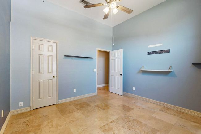 Unfurnished bedroom featuring baseboards, a ceiling fan, visible vents, and a towering ceiling | Image 34