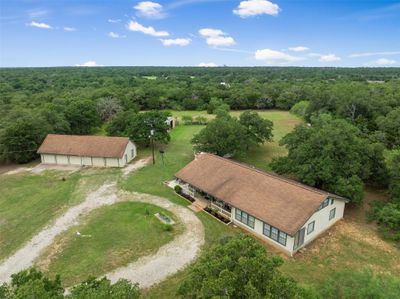 The trees that border this fully fenced and gated propery gives privacy and security and make this property feel bigger than the 5 acres. | Image 1