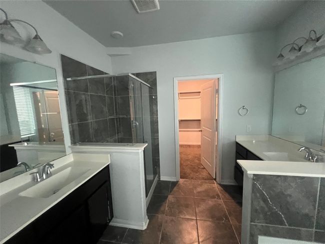 Bathroom featuring a stall shower, two vanities, tile patterned flooring, and a spacious closet | Image 14