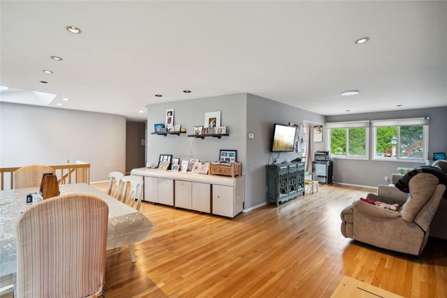 Living room featuring light wood finished floors, a skylight, and recessed lighting | Image 4