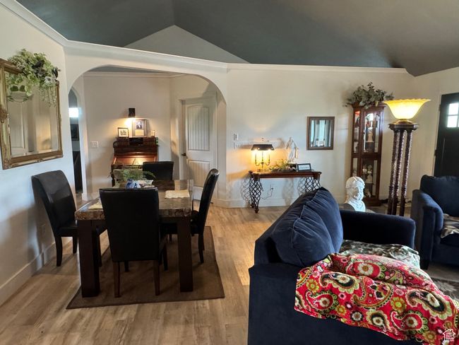 Dining space with lofted ceiling, arched walkways, wood finished floors, and baseboards | Image 8
