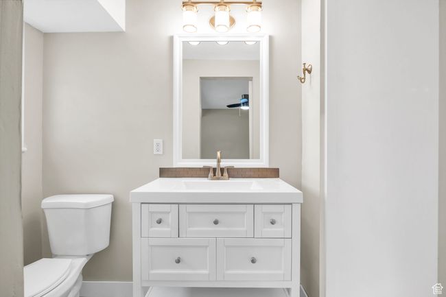 Bathroom featuring vanity, baseboards, toilet, and decorative backsplash | Image 13