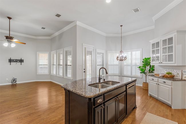 Kitchen with a sink, stainless steel dishwasher, a ceiling fan, light wood-style flooring, and white cabinets | Image 16