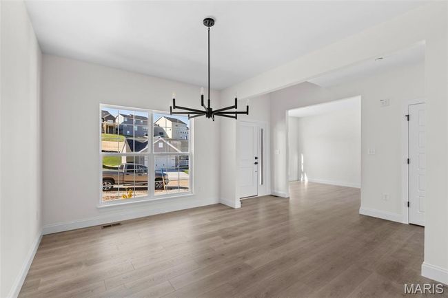 Unfurnished dining area with a chandelier and wood finished floors | Image 23