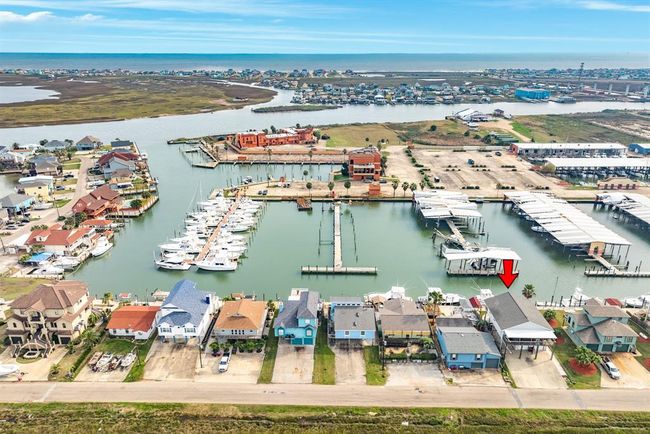 This aerial photo showcases a waterfront property with direct access to a marina under renovation, surrounded by similar homes. The property offers scenic views of the water and is located in a vibrant coastal community. | Image 38