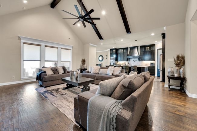 Living room with beamed ceiling, high vaulted ceiling, ceiling fan, dark wood-style floors, and recessed lighting | Image 9