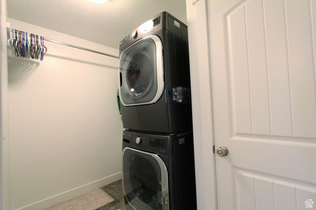 Washroom with stacked washing machine and dryer and baseboards | Image 11