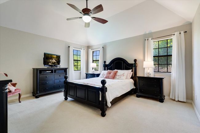 Bedroom with light carpet, multiple windows, vaulted ceiling, ceiling fan, and baseboards | Image 20