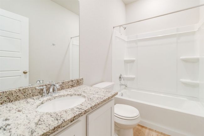 Full bathroom featuring vanity, bathtub / shower combination, wood finished floors, and toilet | Image 21