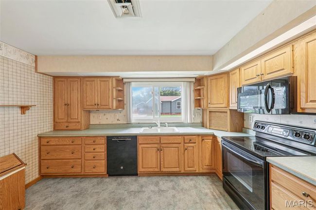 Kitchen featuring open shelves, black appliances, and light countertops | Image 13