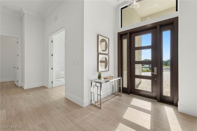 Foyer featuring light hardwood / wood-style floors, ornamental molding, and a towering ceiling | Image 3