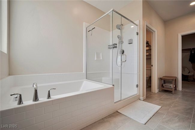 Full bathroom featuring a shower stall, toilet, a spacious closet, and a garden tub | Image 19