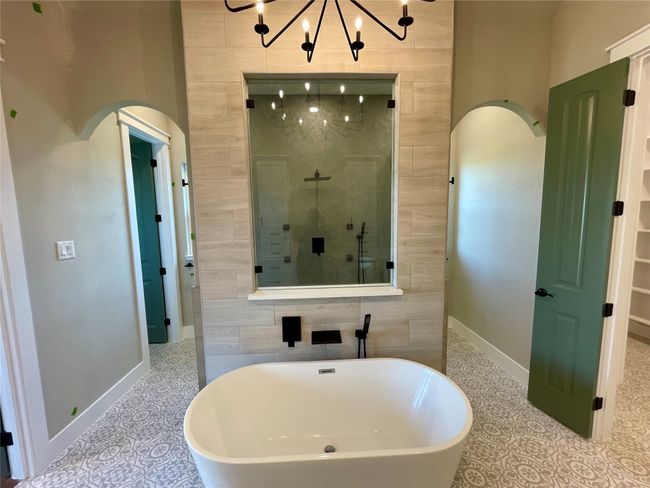 Master bath with double entry shower, vaulted ceiling with wood beam and freestanding tub. Chandelier adds luxury | Image 20