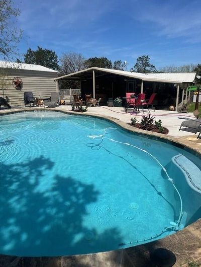 View of swimming pool featuring a patio area | Image 1