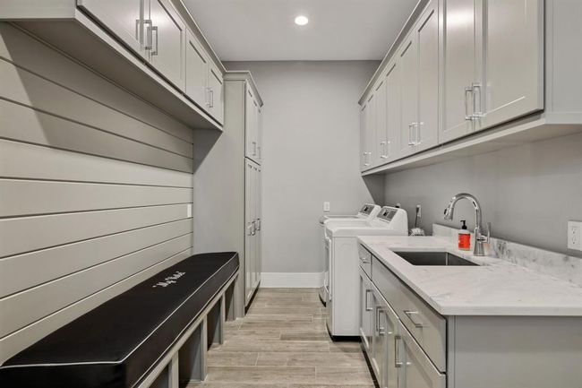 A spacious utility room featuring ample cabinetry for optimal storage and organization. | Image 19