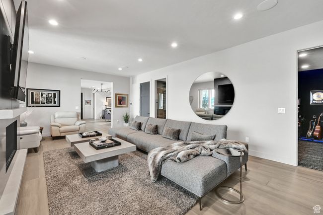 Living room featuring light wood finished floors, recessed lighting, and baseboards | Image 37