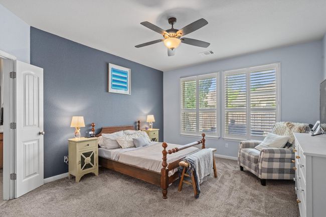 Bedroom with light colored carpet, baseboards, and a ceiling fan | Image 18