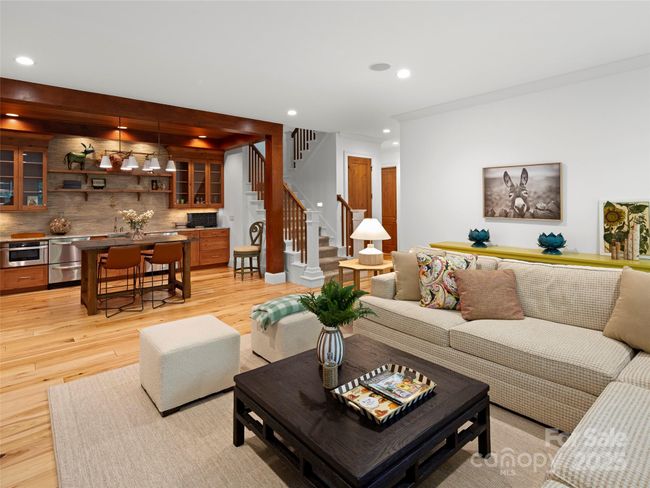 Terrace level living room and entertainment kitchen. Guest bedroom suite and second laundry/utility/storage room are accessed on the right past the stairs. | Image 28
