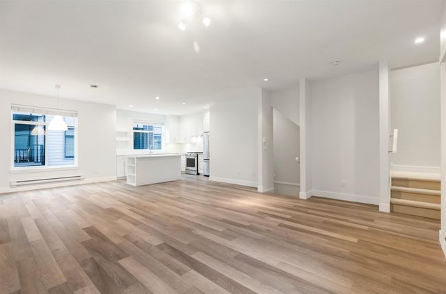 Unfurnished living room with a sink, baseboards, recessed lighting, light wood-style floors, and baseboard heating | Image 6