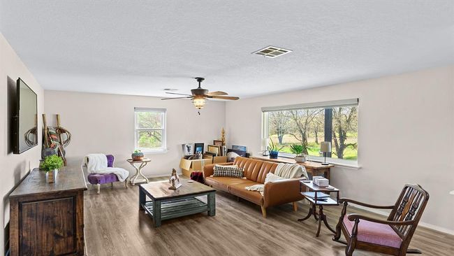 Living room featuring visible vents, ceiling fan, wood finished floors, and a textured ceiling | Image 26