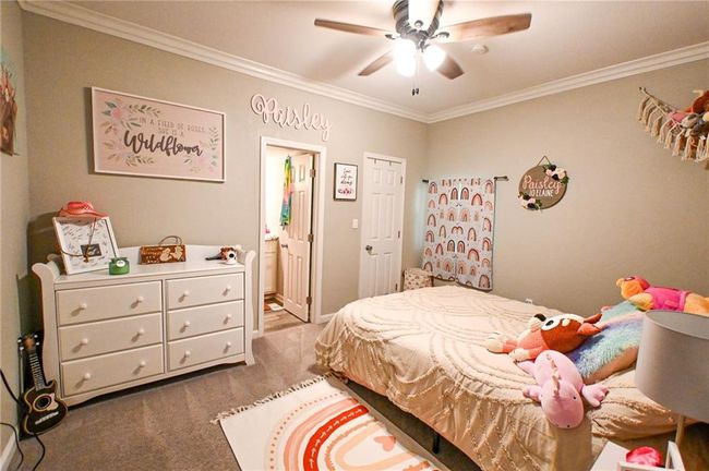 Bedroom featuring ornamental molding, carpet, ensuite bathroom, and a ceiling fan | Image 23