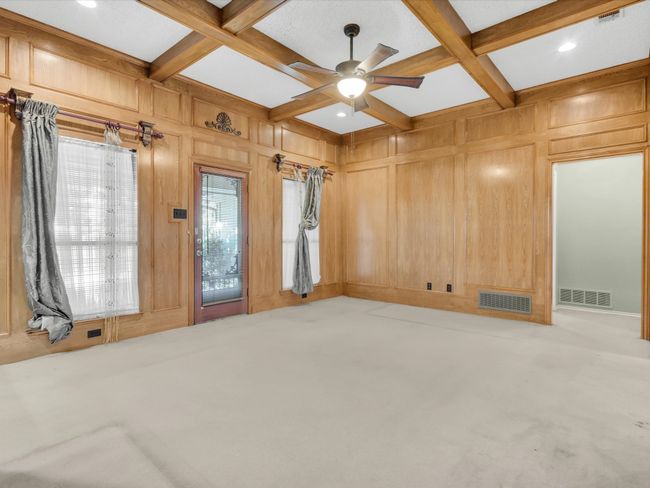 Den has large windows and access to the back patio. | Image 11