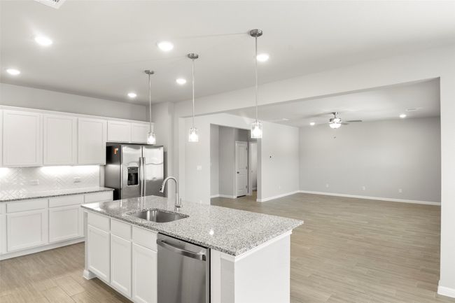 Kitchen featuring appliances with stainless steel finishes, a sink, a center island with sink, ceiling fan, and tasteful backsplash | Image 14
